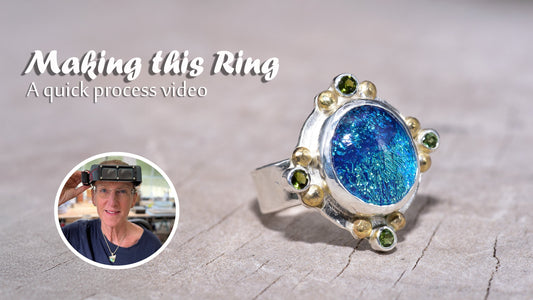 An image of a handmade sterling silver ring with a custom cabochon accented with cubic zirconias and gold