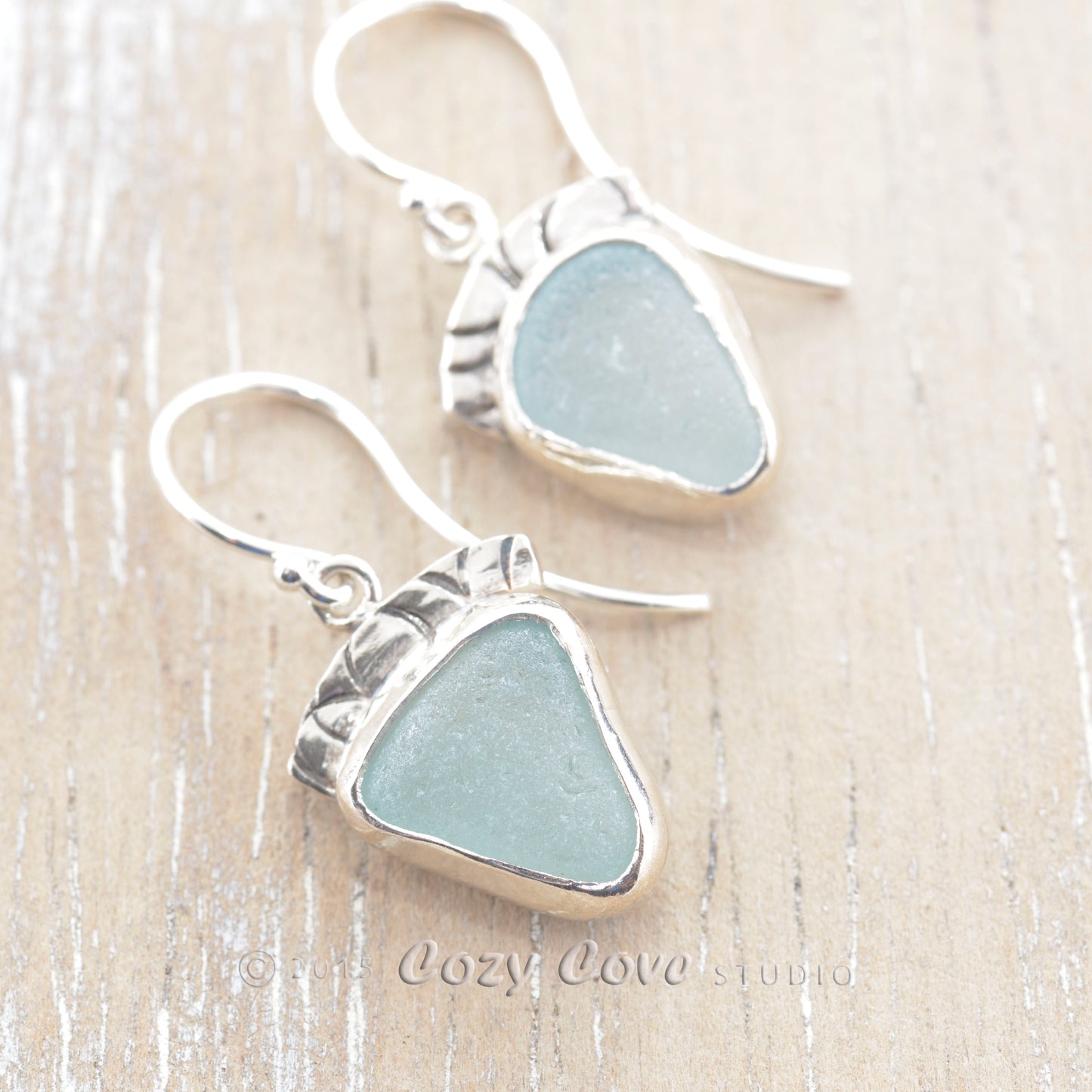 Light blue sea glass earrings in hand made settings of tarnish resistant sterling silver. (E336)
