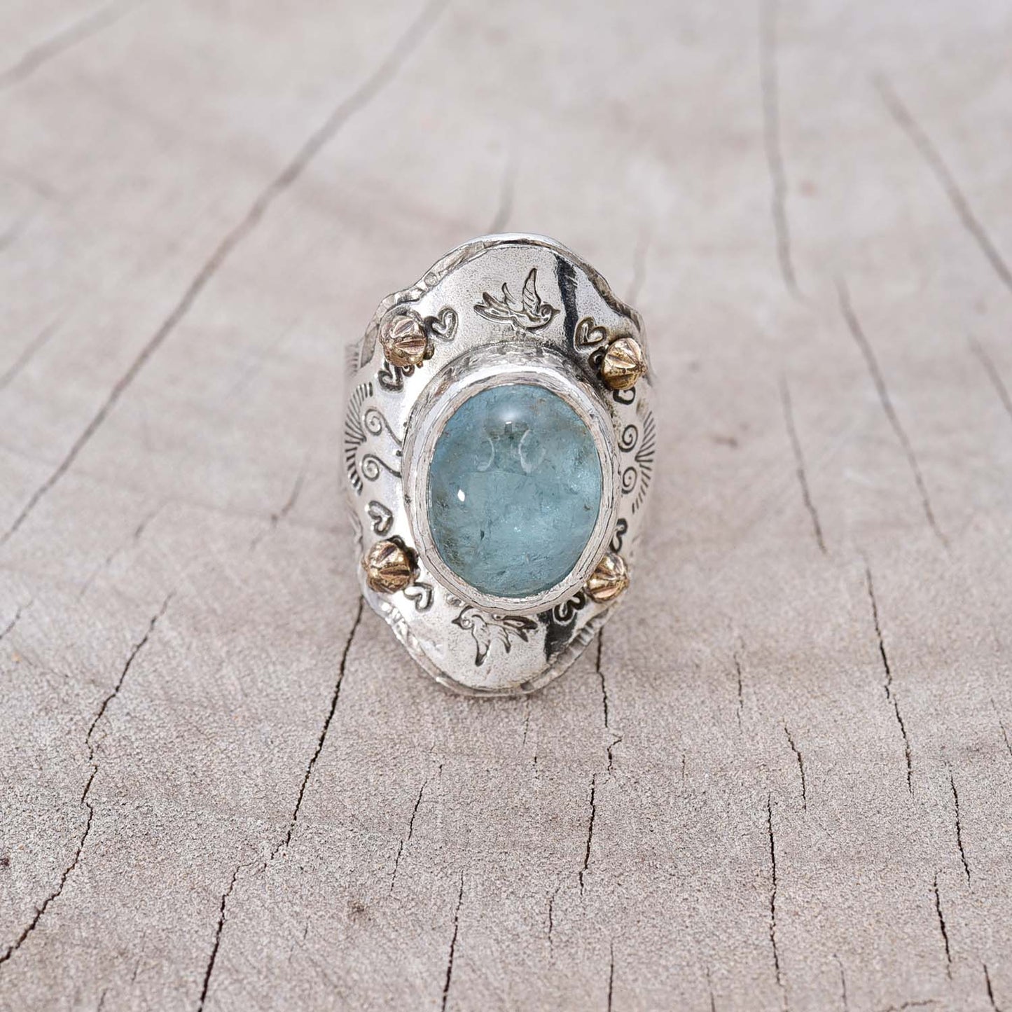 Aquamarine statement ring in a hand crafted setting of sterling silver accented with whimsical stampings and 14K gold studs. (R748)