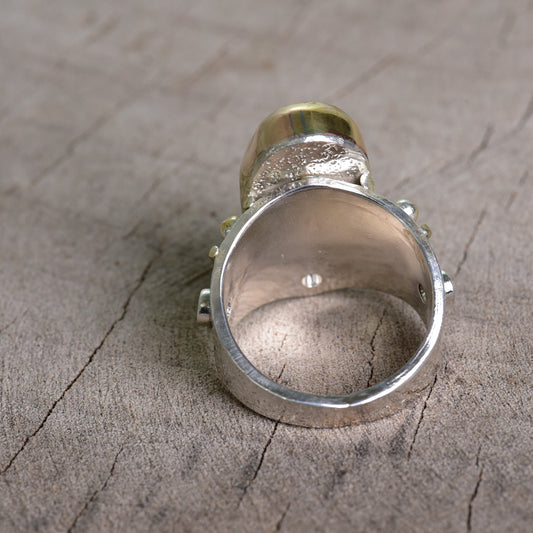 Fused dichroic glass ring in a hand crafted setting of sterling silver with gold accents. (R925)