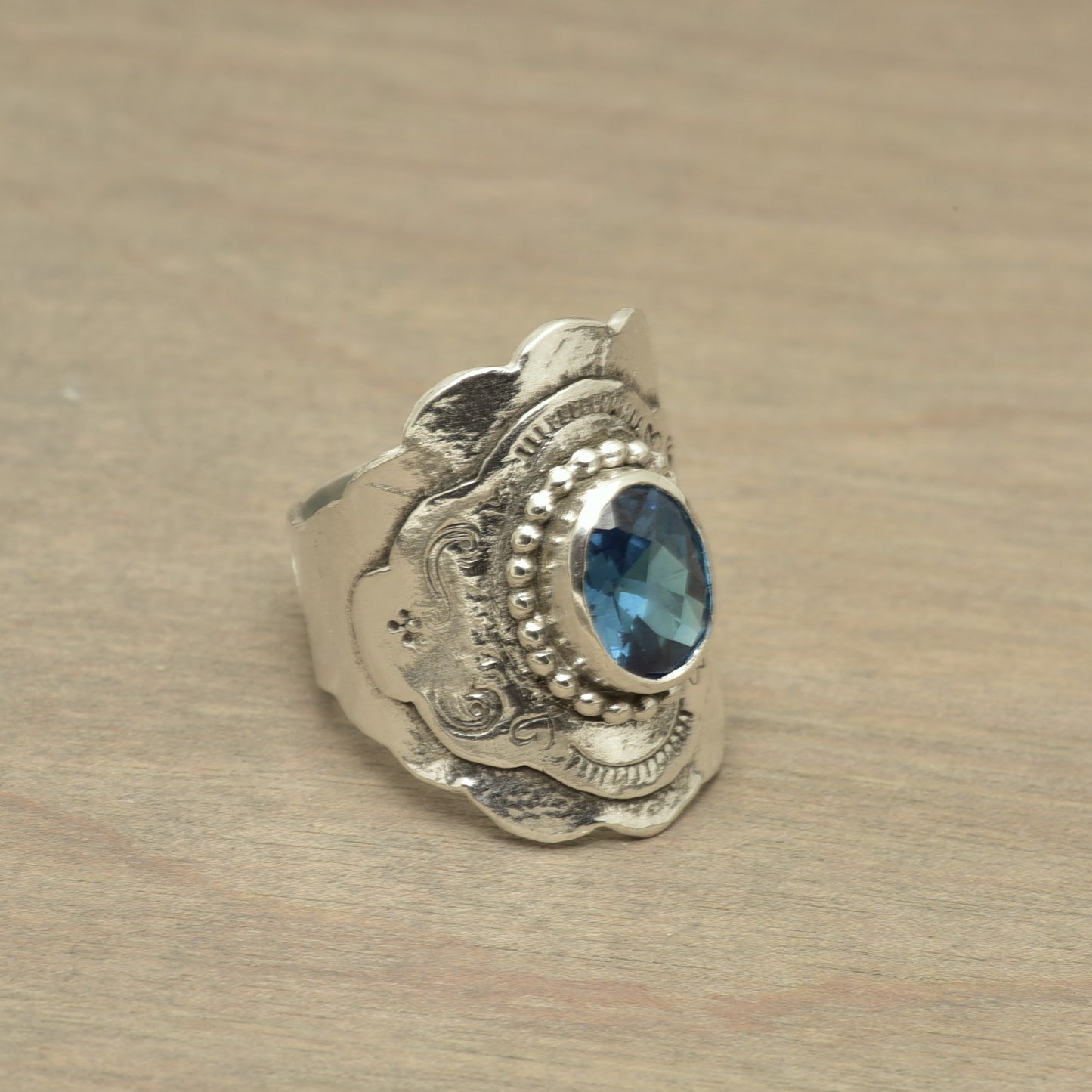Boho style ring with a sparkly blue topaz cubic zirconia in a hand crafted setting of sterling silver. (R516)