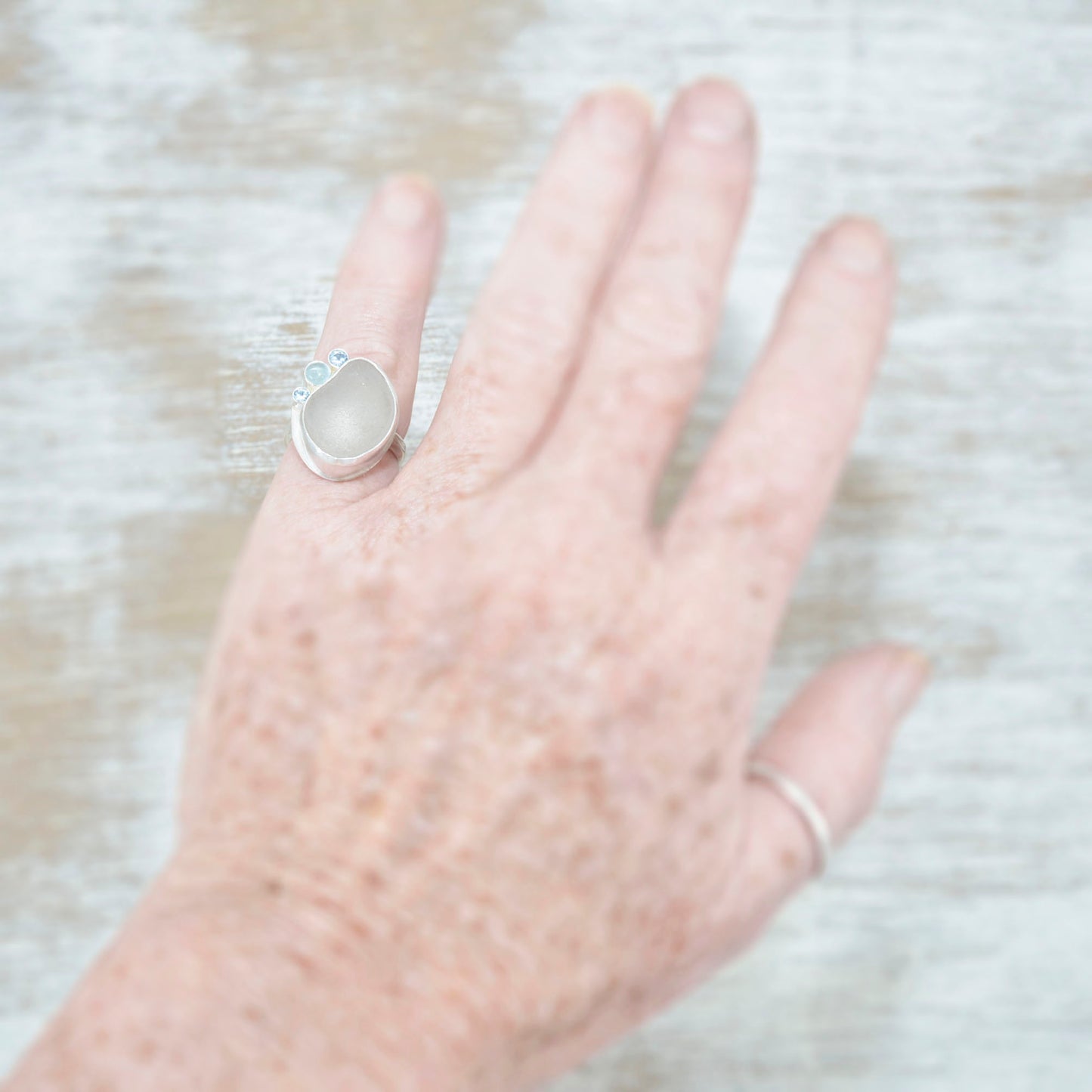 Sea glass ring accented with an aquamarine and sparkly cubic zirconias in sterling silver. (R533)