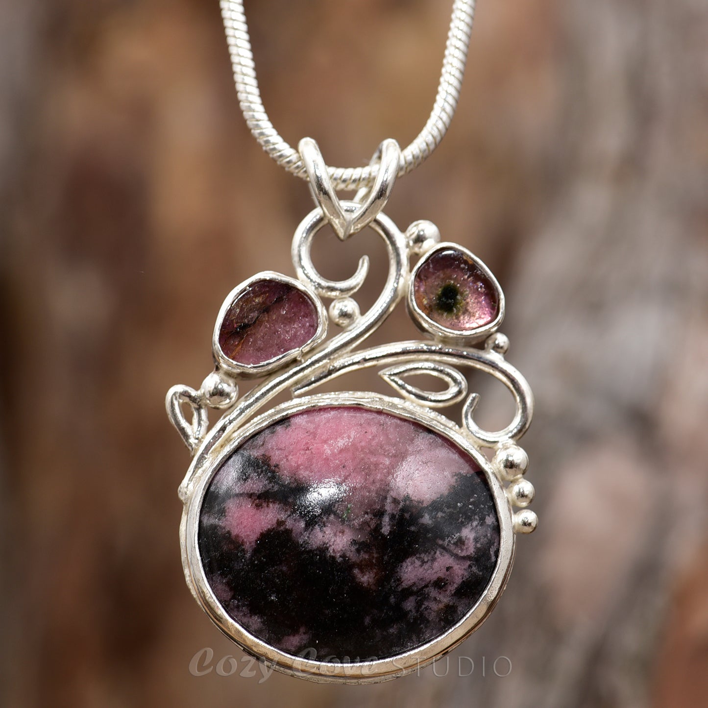 Gemstone necklace with a pink and gray rhodochrosite cabochon and bicolor tourmaline slices in an handcrafted setting of sterling silver. (N737)