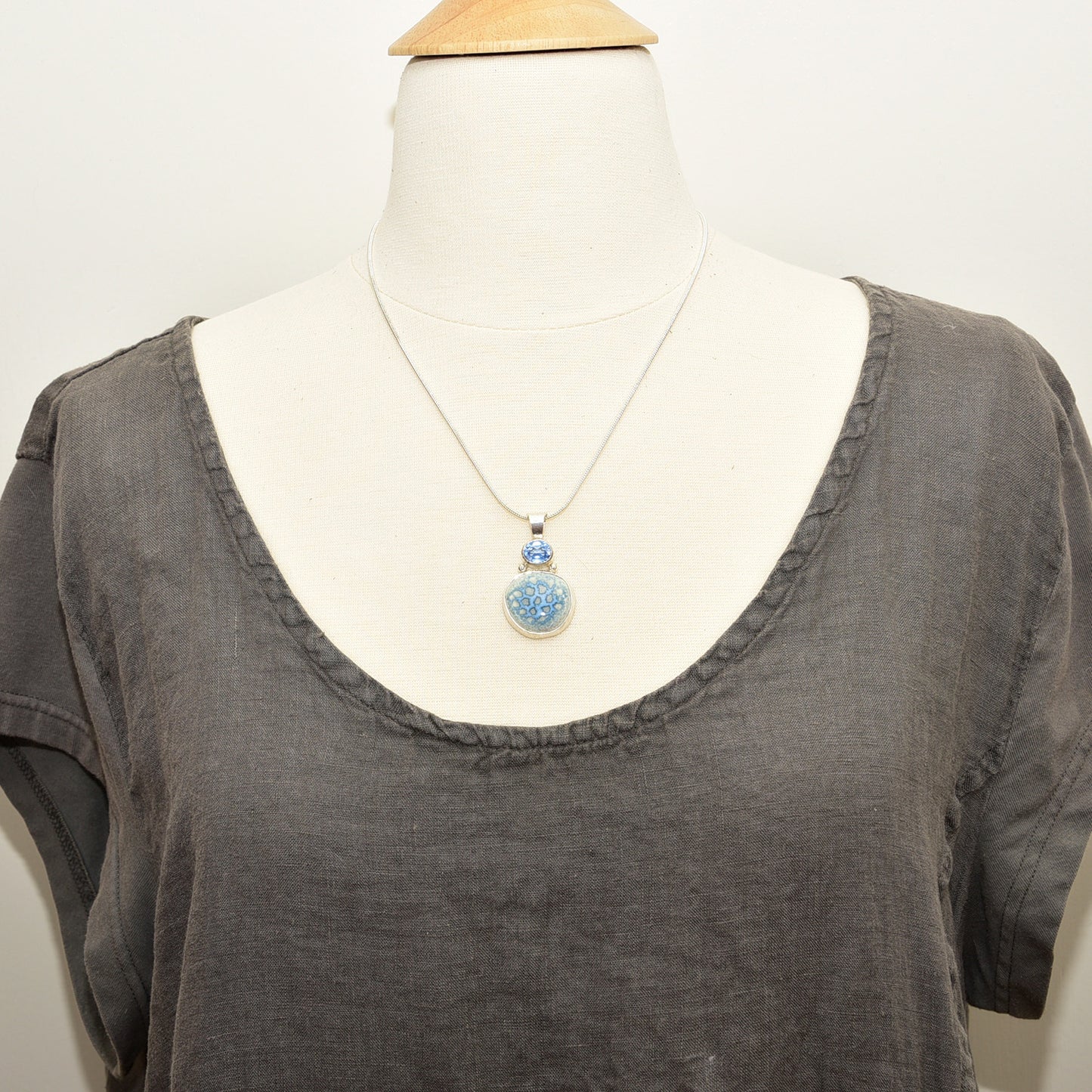 Pendant necklace with hand made enamel cabochon in blue over pale yellow in a hand crafted setting of sterling silver. (N765)