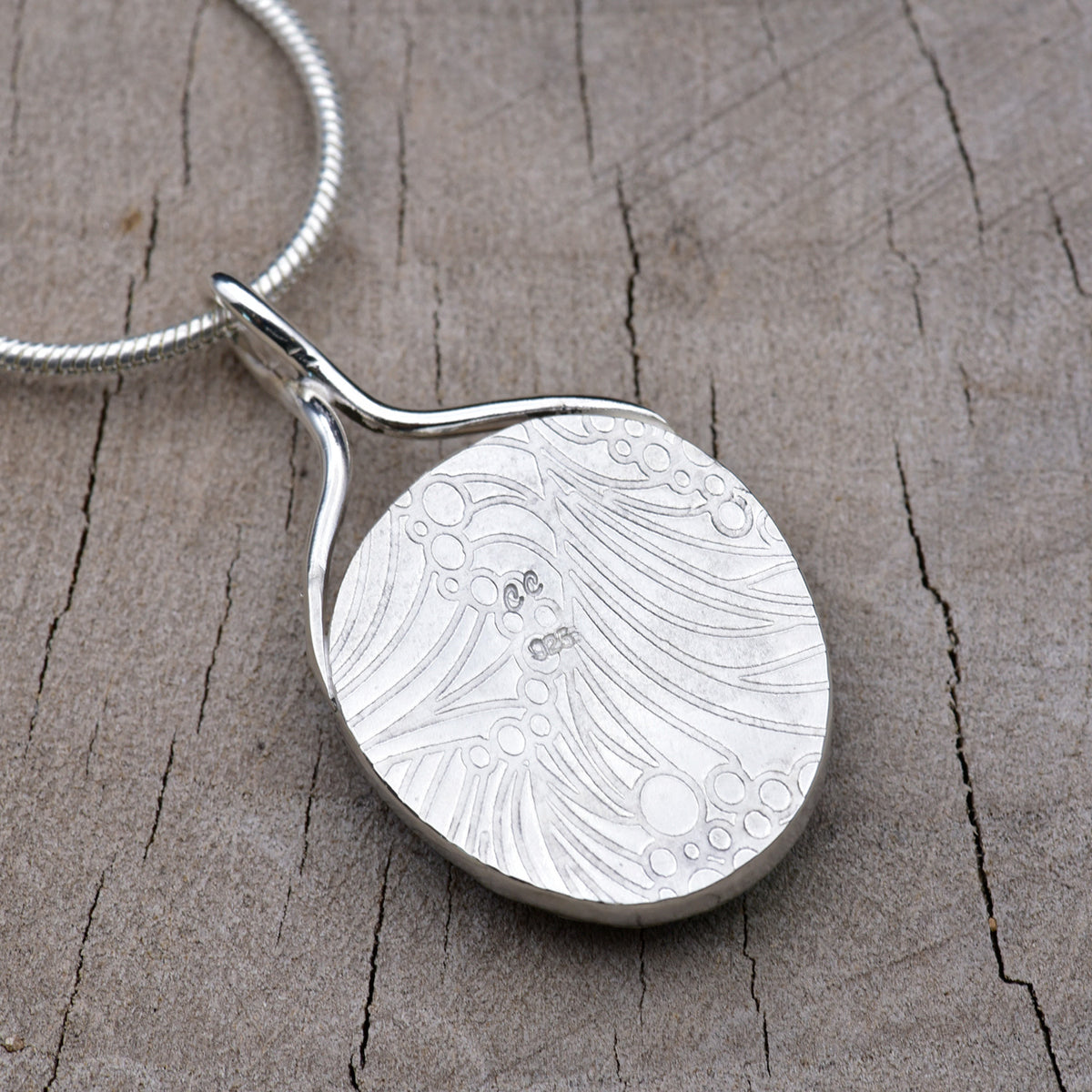 Back of the pendant showing the embossed wave and bubble texture with the CC maker's mark and 925 sterling silver hallmark.