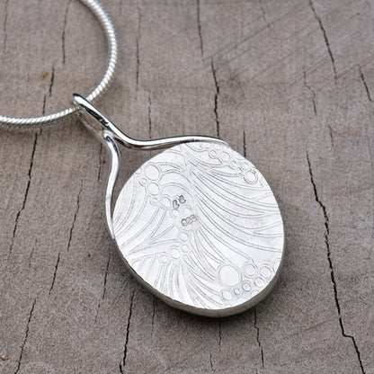 Back of the pendant showing the embossed wave and bubble texture with the CC maker's mark and 925 sterling silver hallmark.