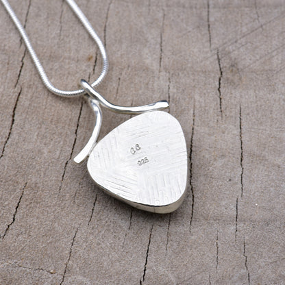 Back of the shield-shaped pendant showing the embossed crosshatch texture with the CC maker's mark and 925 sterling silver hallmark.