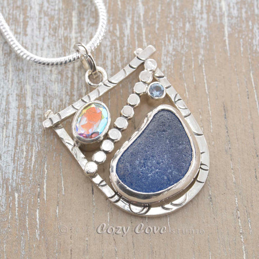 Cornflower blue sea glass pendant necklace in a handmade original setting of tarnish resistant sterling silver accented with a faceted opalescent topaz and a sparkly CZ. (E343)