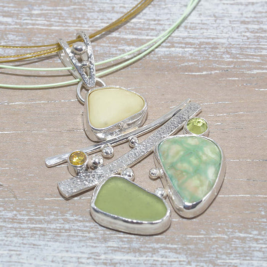 Sea glass and vitreous enamel pendant necklace in a hand crafted setting of sterling silver accented with semi-precious gemstones. (N619)