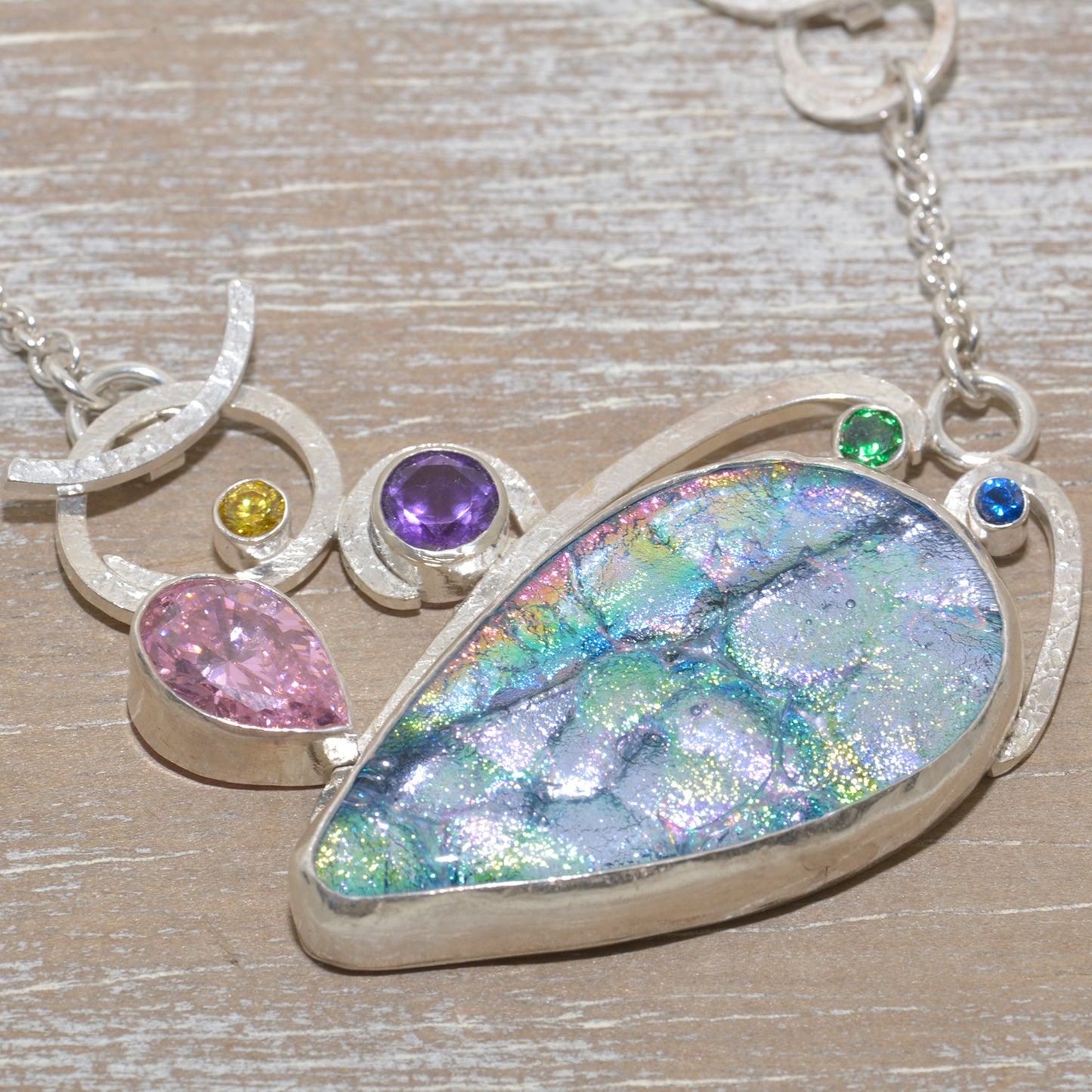 Dichroic glass and gemstone pendant in a hand crafted setting of sterling silver. (N676)