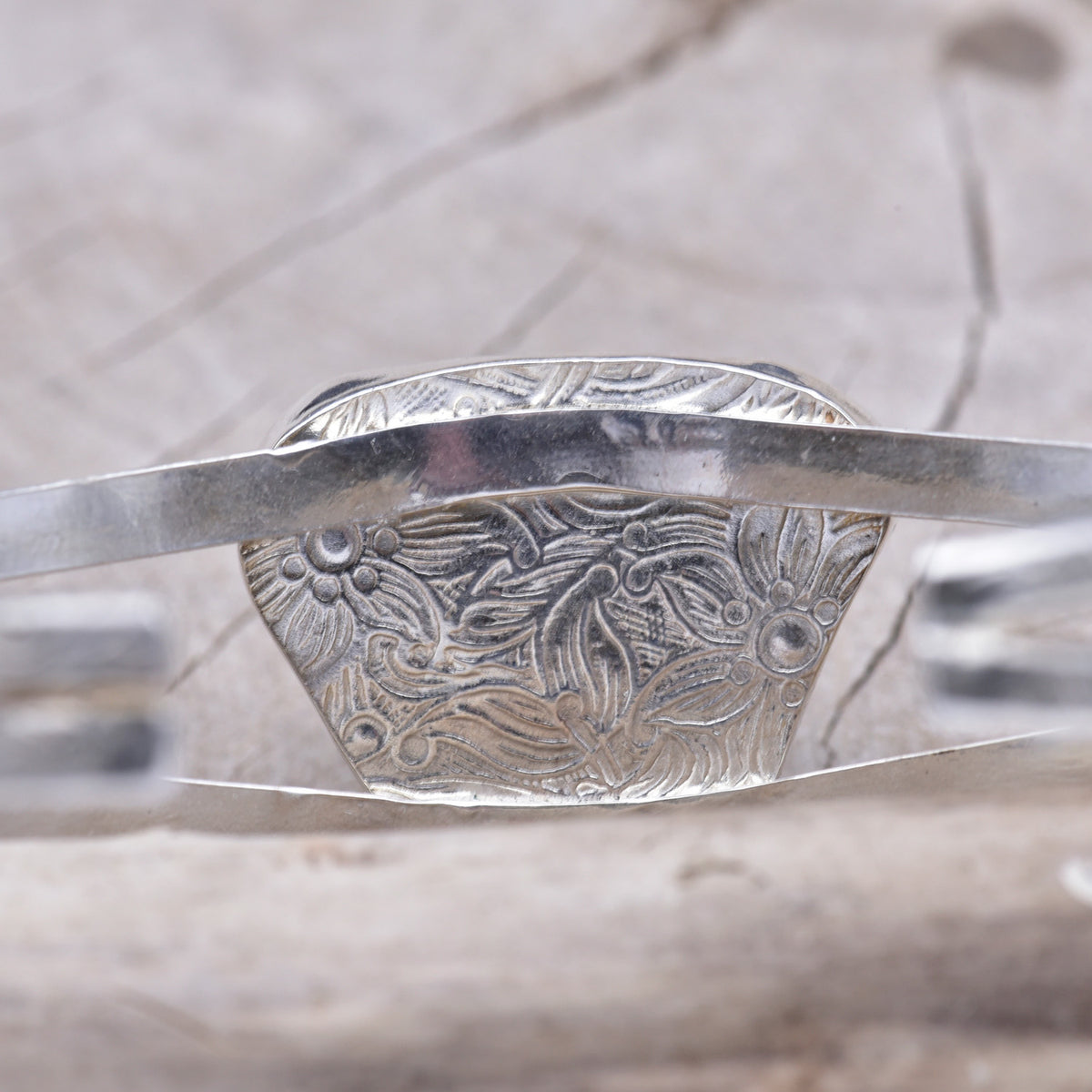 Underside of the sea glass bezel, pattern-rolled with a floral design that sits against the wrist