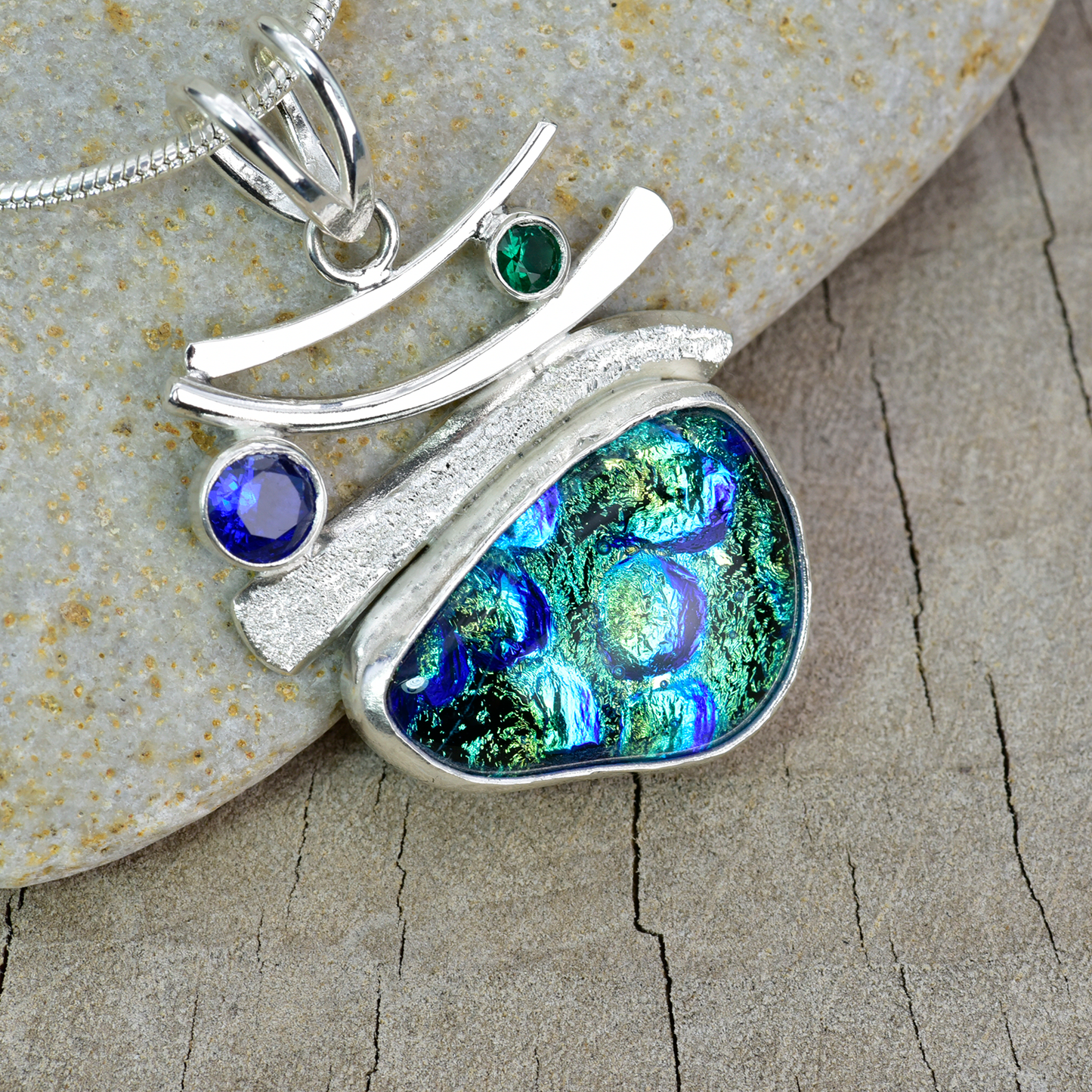 Fused dichroic glass pendant in a hand crafted setting of sterling silver. (N898)