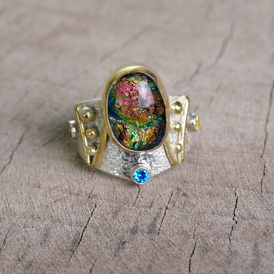 Fused dichroic glass ring in a hand crafted setting of sterling silver with gold accents. (R925)