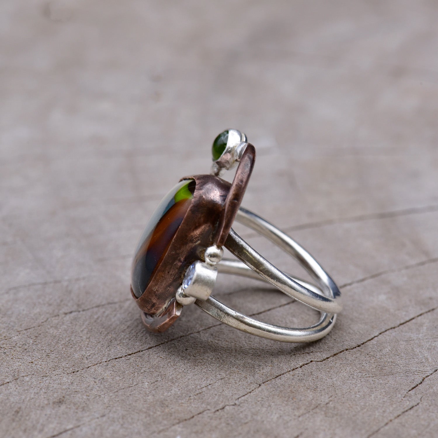Silver ring in copper and silver on a wooden surface