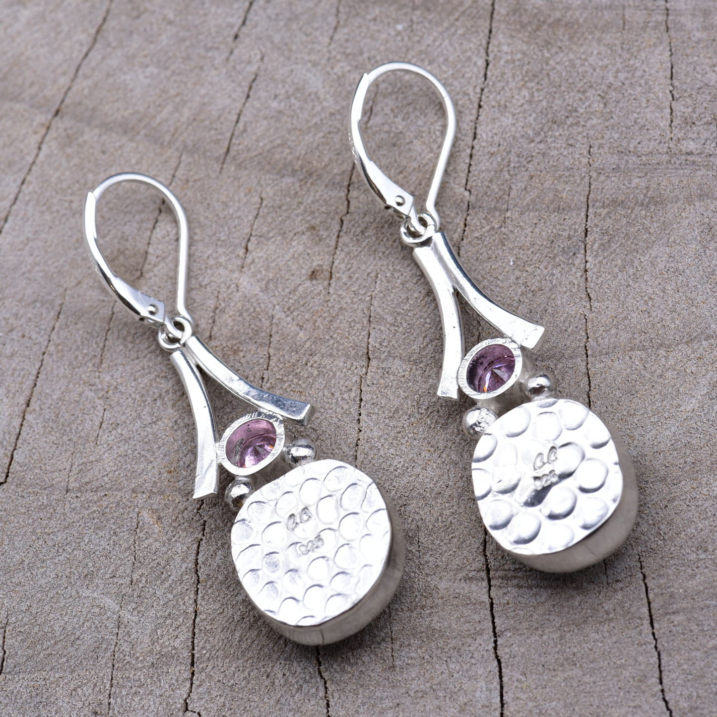 Backs of the sterling silver earrings showing the pebbled embossed texture and the CC maker's mark