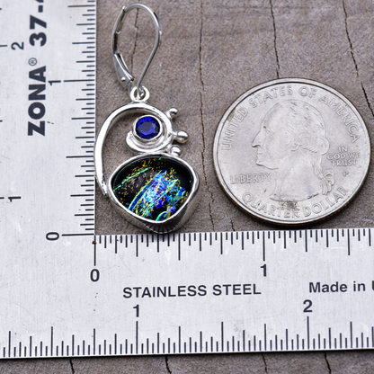 Dichroic glass dangle earring beside a ruler and a quarter, measuring about 1½ inches from ear wire to bottom