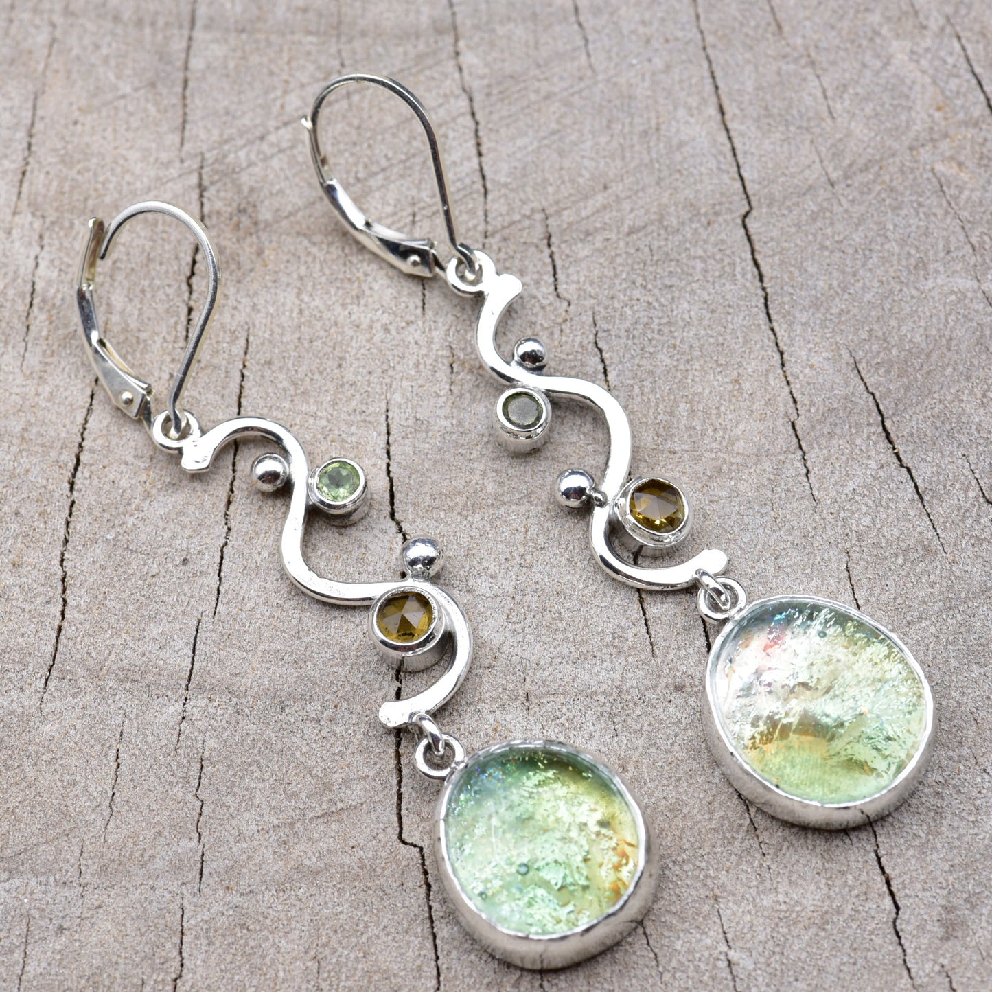 Pair of seafoam green and gold dichroic fused glass dangle earrings in hand-formed Argentium sterling silver waves with peridot and citrine accents