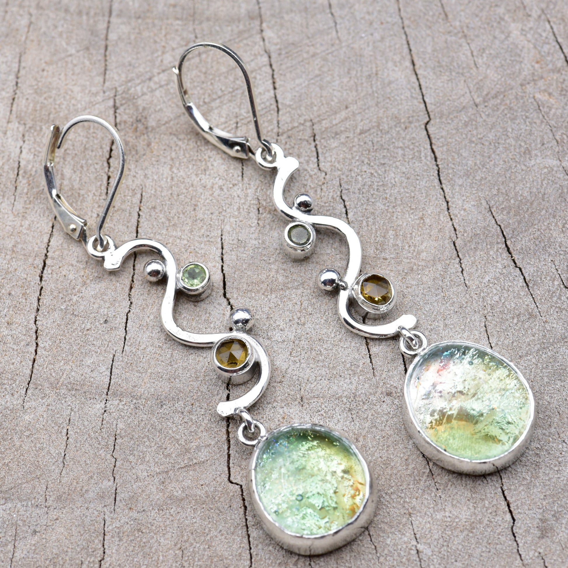 Pair of seafoam green and gold dichroic fused glass dangle earrings in hand-formed Argentium sterling silver waves with peridot and citrine accents