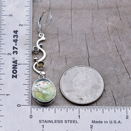One earring beside a ruler and a quarter, measuring about 2 1/4 inches from the top of the ear wire to the bottom of the glass