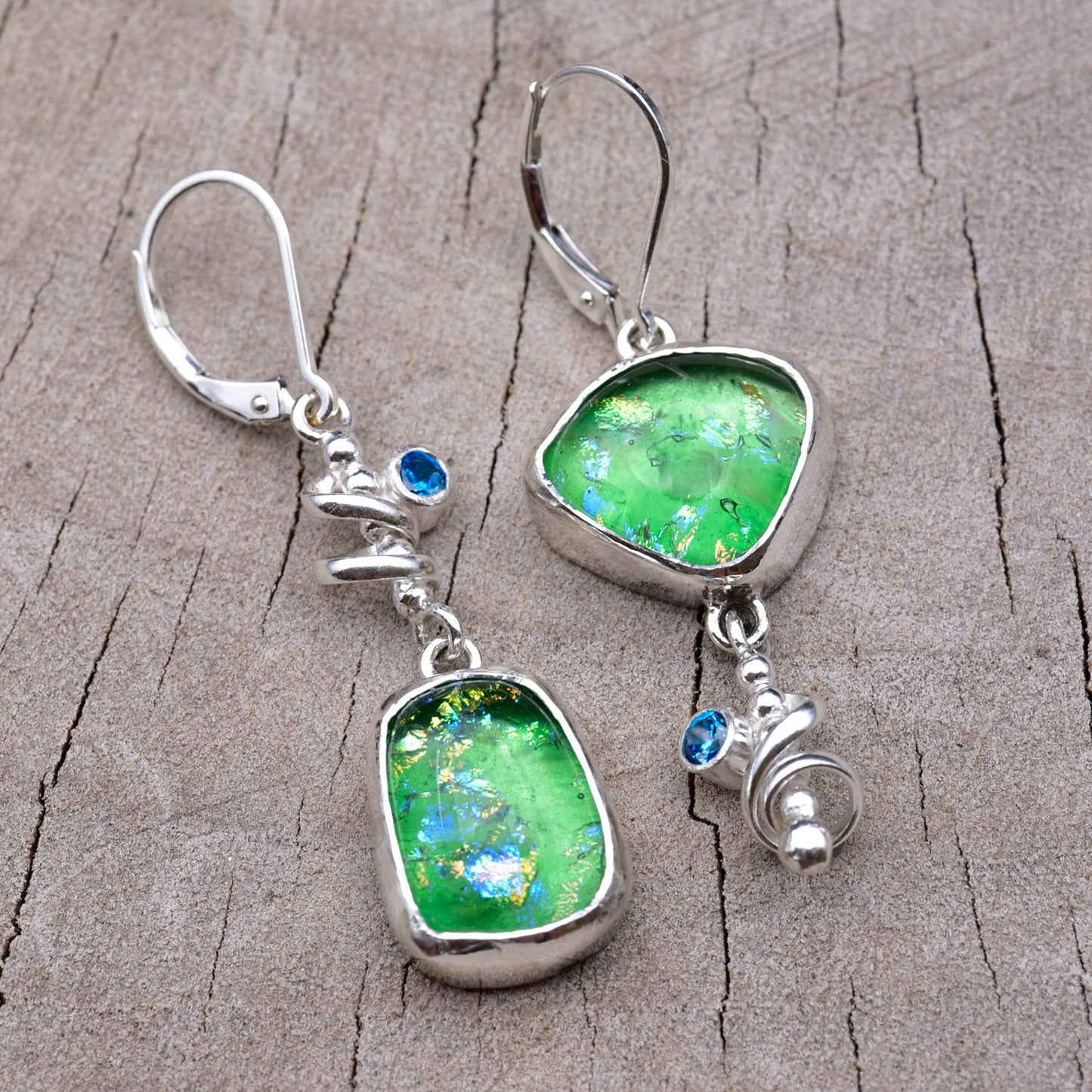 Pair of asymmetric spring green dichroic fused glass dangle earrings with gold and blue flashes, in Argentium sterling silver spirals with blue cubic zirconia