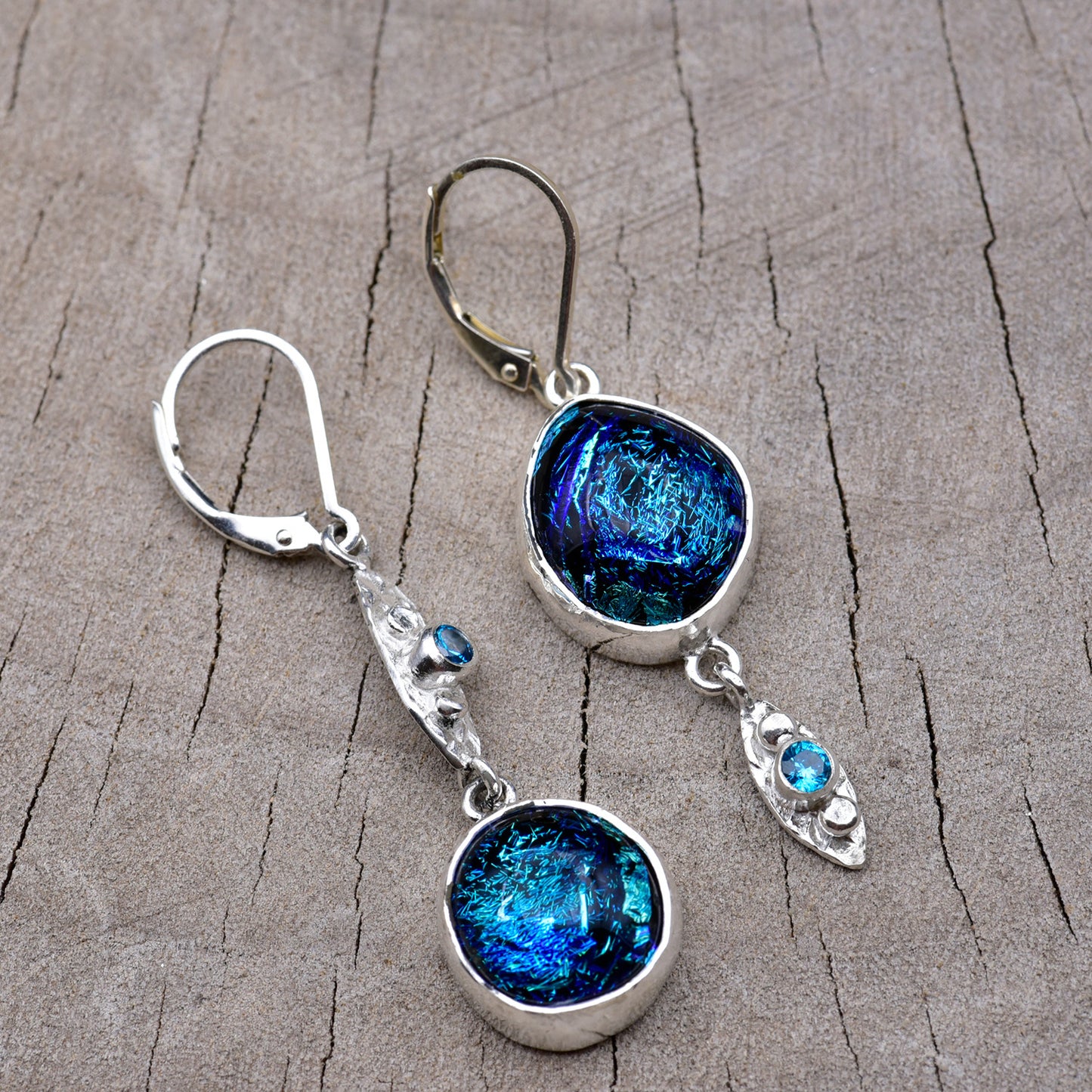 Pair of asymmetric sapphire blue and turquoise dichroic fused glass dangle earrings in textured Argentium sterling silver marquise links with blue cubic zirconia