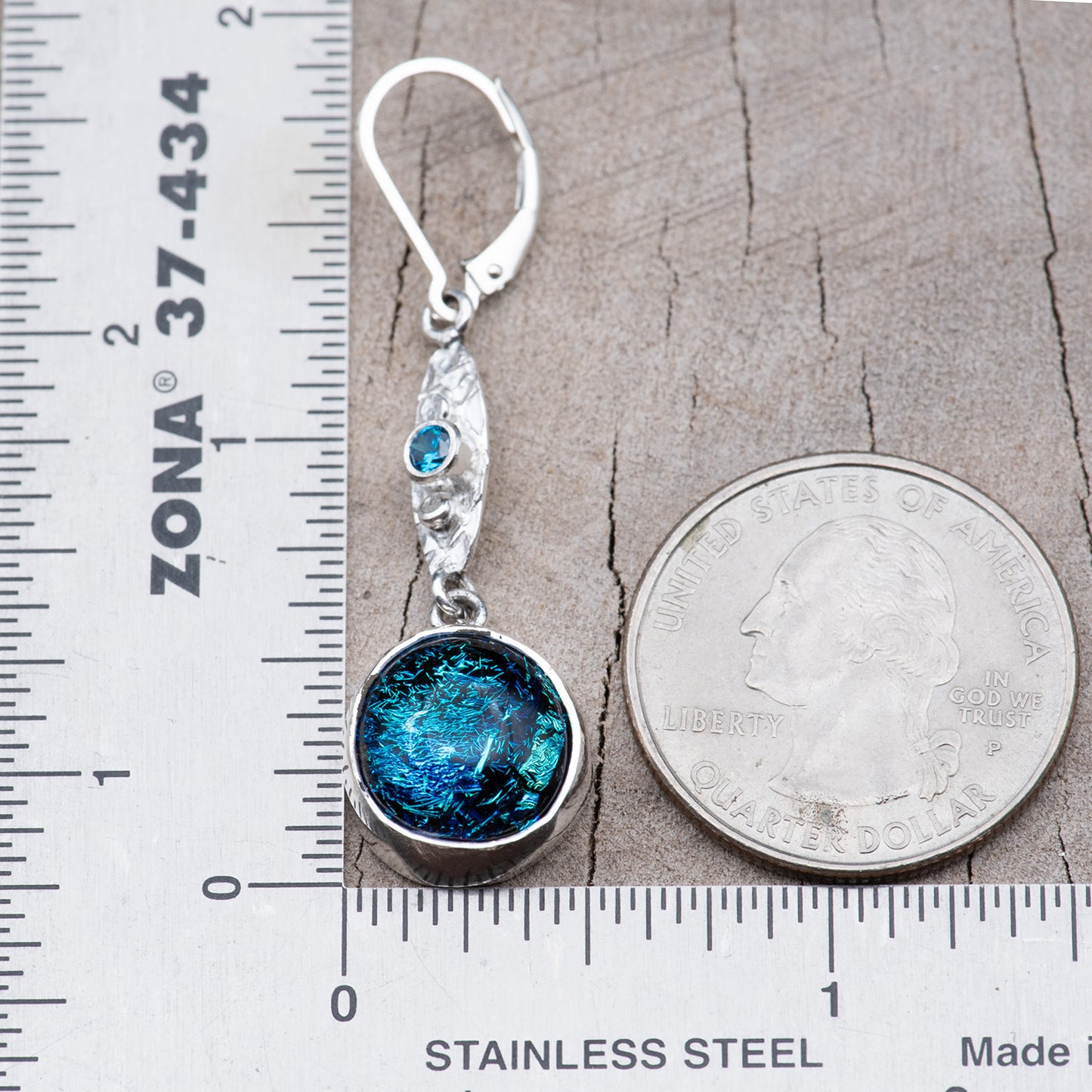 One earring beside a ruler and a quarter, measuring about 1 7/8 inches from the top of the ear wire to the bottom of the glass