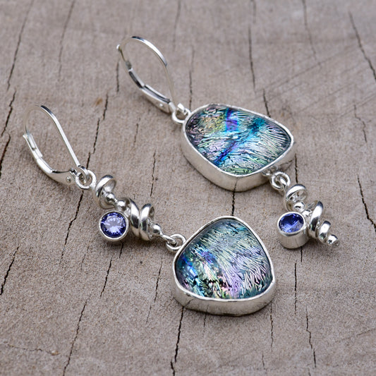 Handmade asymmetric dichroic glass dangle earrings with teal, blue and lavender streaked glass, Argentium sterling silver spiral dangles and violet blue cubic zirconia accents, on weathered wood