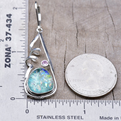 Aqua dichroic glass earring beside a ruler and a quarter for scale, measuring about 2 inches long