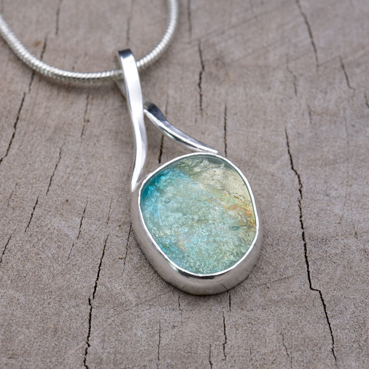 Turquoise and cream dichroic fused glass pendant set in a hand-fabricated Argentium sterling silver bezel with a sculptural forged ribbon bail.