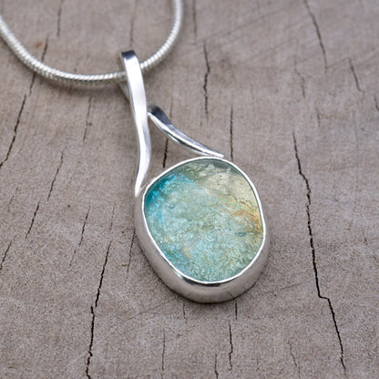 Turquoise and cream dichroic fused glass pendant set in a hand-fabricated Argentium sterling silver bezel with a sculptural forged ribbon bail.