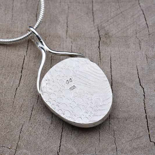 Back of the pendant showing the embossed bubble and wave texture with the CC maker's mark and 925 sterling silver hallmark.