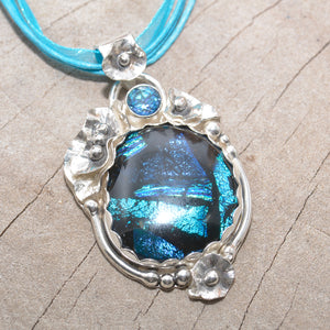 Dichroic glass pendant in shades of blue in a setting of sterling silver. (N378)