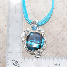 Load image into Gallery viewer, Dichroic glass pendant in shades of blue in a setting of sterling silver. (N378)
