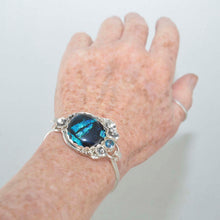 Load image into Gallery viewer, Statement cuff bracelet with a dichroic glass in shades of blue in a setting of sterling silver. (B378)
