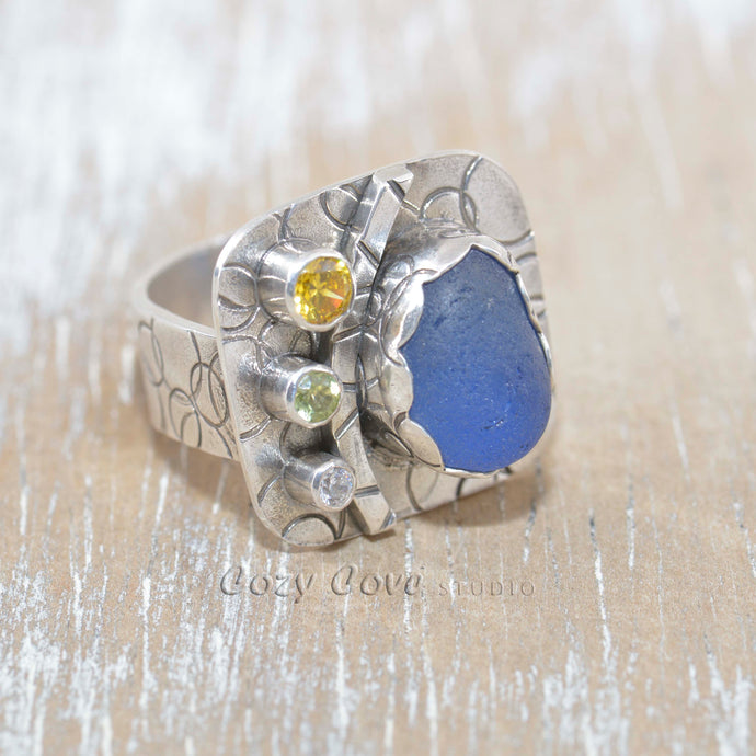 Sea glass statement ring with cornflower blue sea glass accented with sparkly CZs in sterling silver. (R388)