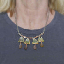 Load image into Gallery viewer, Statement necklace in mixed metals of sterling silver and copper with green tortoise motif enameled copper dangles holding amber sea glass with sterling silver rivets.
