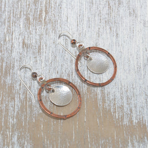 Mixed metal hoop earrings in copper with textured disks of tarnish resistant sterling silver. (E440)