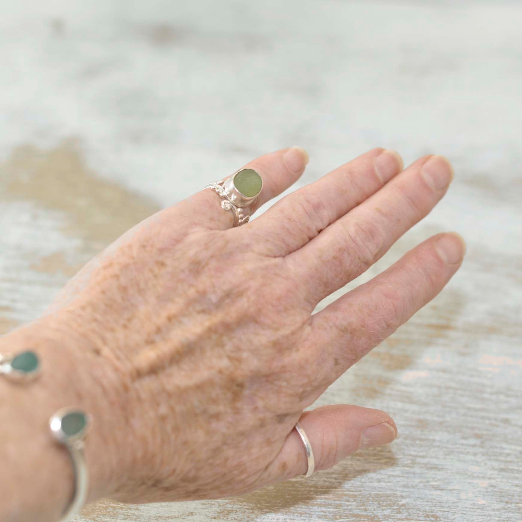 Green sea glass ring in sterling silver as worn on hand