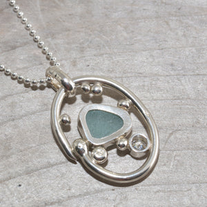 Sea glass necklace in a hand crafted tarnish resistant sterling silver setting accented with pebbles and a sparkly CZ. (N492)