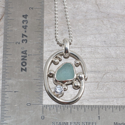 Sea glass necklace in a hand crafted tarnish resistant sterling silver setting accented with pebbles and a sparkly CZ. (N492)