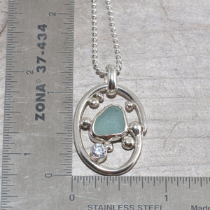 Sea glass necklace in a hand crafted tarnish resistant sterling silver setting accented with pebbles and a sparkly CZ. (N492)