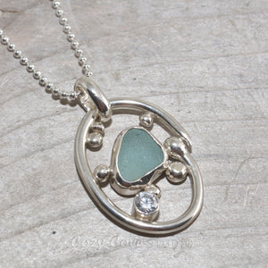 Sea glass necklace in a hand crafted tarnish resistant sterling silver setting accented with pebbles and a sparkly CZ. (N492)