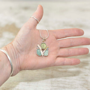 Sea glass pendant necklace with tones of green and blue sea glass in a hand crafted setting of tarnish resisant sterling silver accented with 22 K gold (N506)