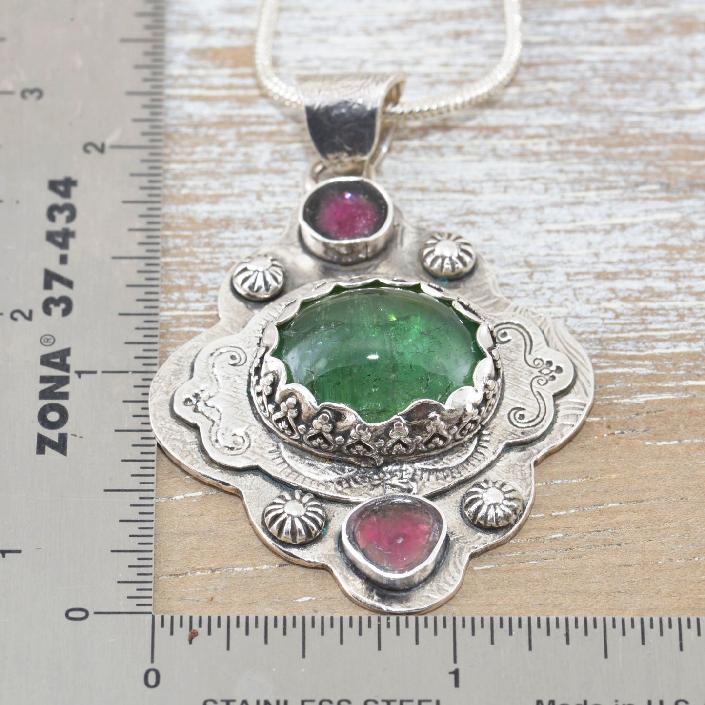 Boho style pendant necklace with a large green tourmaline in  hand crafted sterling silver setting accented with watermelon tourmaline slices. (N513)