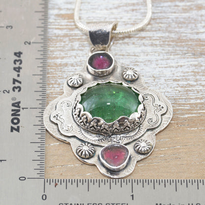 Boho style pendant necklace with a large green tourmaline in  hand crafted sterling silver setting accented with watermelon tourmaline slices. (N513)