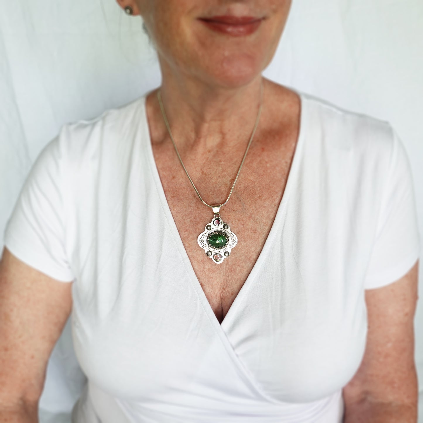 Boho style pendant necklace with a large green tourmaline in  hand crafted sterling silver setting accented with watermelon tourmaline slices. (N513)