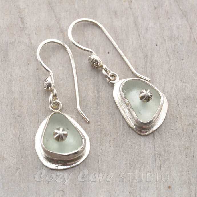 Sea glass earrings in pale blue accented with sterling silver studs.