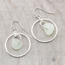 Load image into Gallery viewer, Pale green sea glass earrings encircled by textured hoops of sterling silver.
