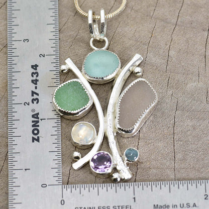 Sea glass statement pendant necklace in a hand crafted setting of tarnish resistant sterling silver accented with semi-precious gemstones. (N608)