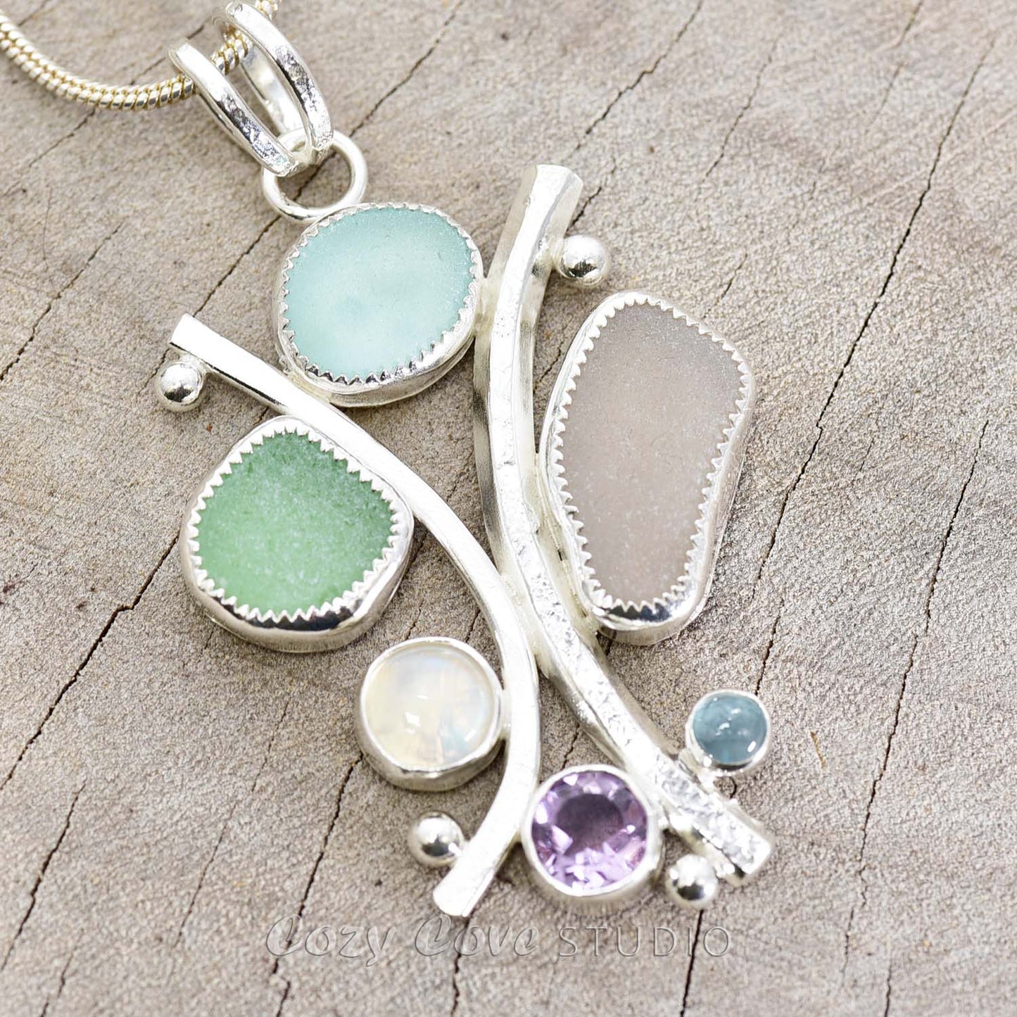 Sea glass statement pendant necklace in a hand crafted setting of tarnish resistant sterling silver accented with semi-precious gemstones. (N608)